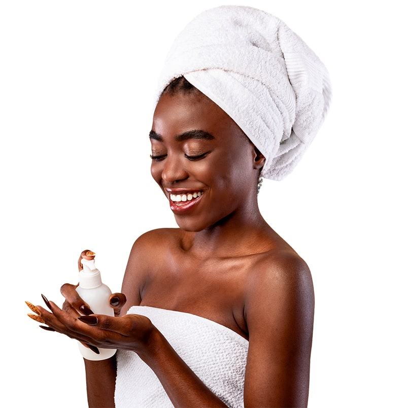 A happy Afro-American woman applying body lotion.